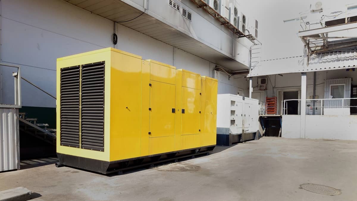 A large yellow generator standing in an industrial yard