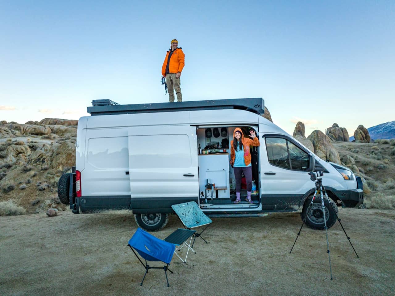 Campers at a van conversion parked in a rocky landscape